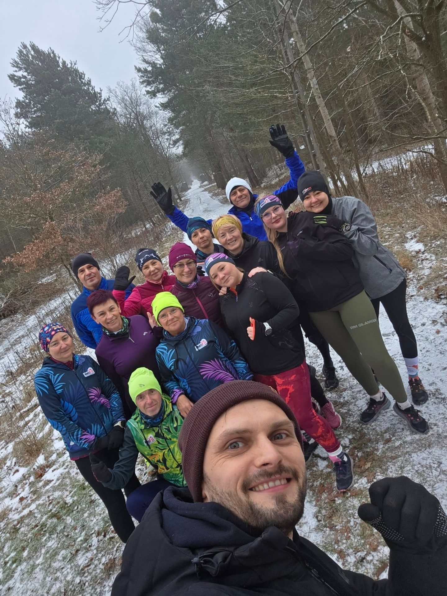 Grupowy trening biegowy zimą w lesie